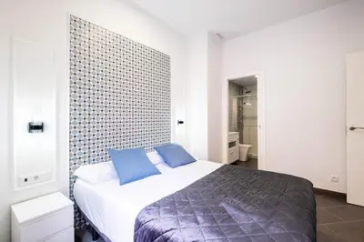 a bedroom with a large bed with blue pillows at New and Modern Apartment with Comfy Beds in Valencia