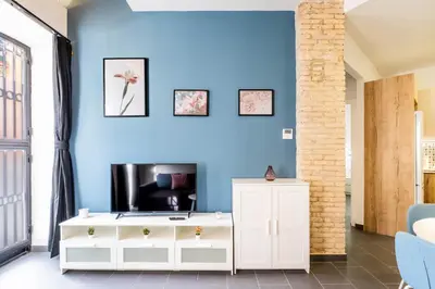 a living room with a tv and a blue wall at New and Modern Apartment with Comfy Beds in Valencia