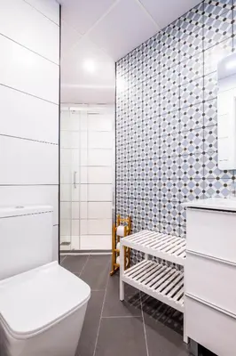 a bathroom with a toilet and a tiled wall at Charming and Comfortable Apartment with Inviting Atmosphere in Valencia