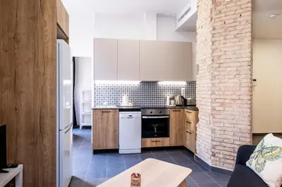 a kitchen with white cabinets and a brick wall at Charming and Comfortable Apartment with Inviting Atmosphere in Valencia