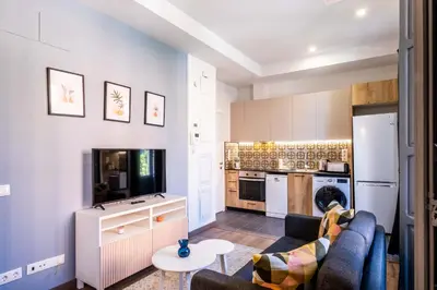 a living room with a couch and a kitchen at Classy Studio Apartment with Unique Design in Valencia