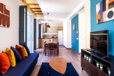 a living room with a blue couch and a table at Well Lit and Creatively Designed Apartment in Valencia