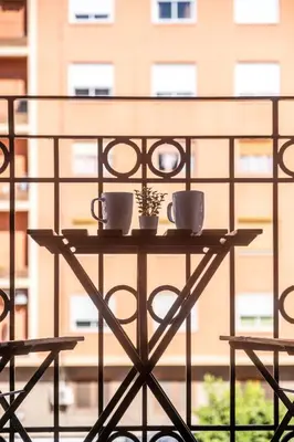 a table with two cups and a plant on it at Well Lit and Creatively Designed Apartment in Valencia