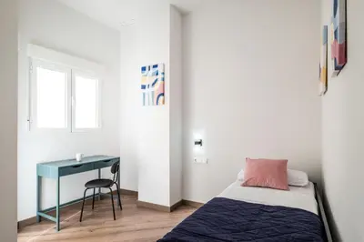 a small bedroom with a bed and a desk at Well Lit and Creatively Designed Apartment in Valencia