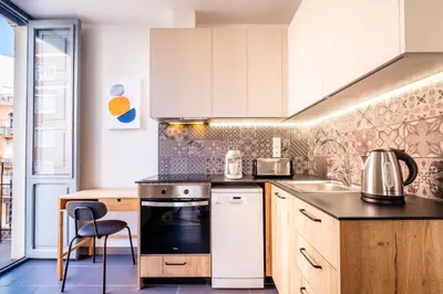 a kitchen with white cabinets and a stove top oven at Amazing Apartment with aFun and Friendly Atmosphere in Valencia