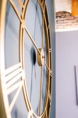 a gold clock on a wall with a ladder at Amazing Apartment with aFun and Friendly Atmosphere in Valencia