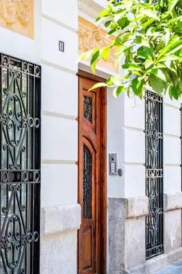 a wooden door on a white building with wrought iron gates at Amazing Apartment with aFun and Friendly Atmosphere in Valencia