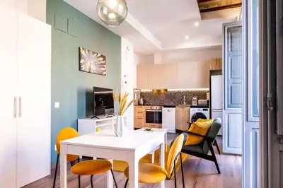 a kitchen and dining room with a white table and chairs at Beautifully Designed Studio with Lots of Natural Light in Valencia