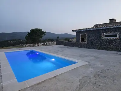a large blue swimming pool in front of a house at EL ARA DE LOS ORISHAS in Siete Aguas