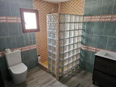 a bathroom with a toilet and a sink and a window at EL ARA DE LOS ORISHAS in Siete Aguas