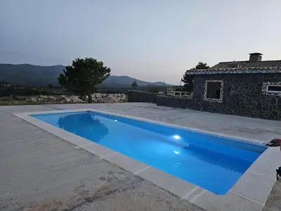 a blue swimming pool in front of a house at EL ARA DE LOS ORISHAS in Siete Aguas