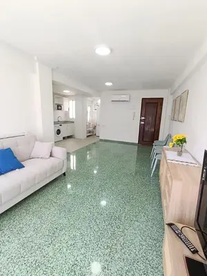 a living room with a white couch and a kitchen at Apartamento Lyon in Cullera