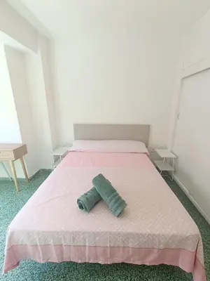 a bed with two pillows on it in a room at Apartamento Lyon in Cullera