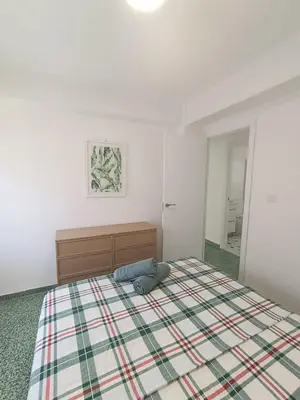 a bedroom with a bed with a plaid blanket at Apartamento Lyon in Cullera