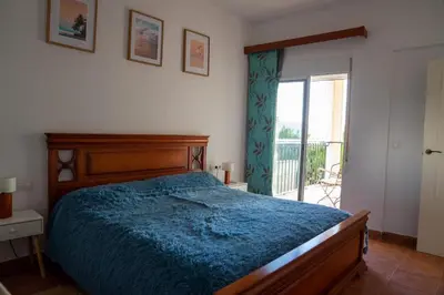 a bedroom with a blue bed and a balcony at Beautiful Villa with huge private pool and vineyard view in Valencia