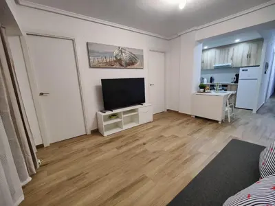 a living room with a flat screen tv on a wooden floor at Near Beach Cullera in Cullera
