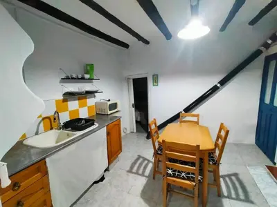a kitchen with a table and a sink and a table at Casa de pueblo García Marquez in Geldo