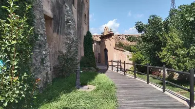 a wooden walkway next to a building with a fence at Casa de pueblo García Marquez in Geldo