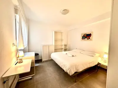 a white bedroom with a bed and two lamps at Malvarrosa Beach in Valencia