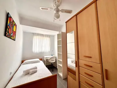 a small bedroom with a bed and a cabinet at Malvarrosa Beach in Valencia