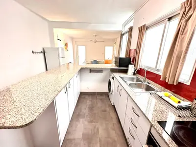 a kitchen with white counter tops and a sink at Malvarrosa Beach in Valencia