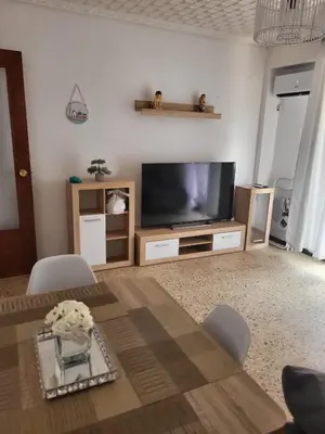 a living room with a television and a table at Virgen de los desamparados in Puerto de Sagunto