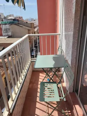 a green chair sitting on a balcony with a window at Virgen de los desamparados in Puerto de Sagunto