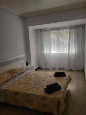 a bedroom with a large bed and a window at Virgen de los desamparados in Puerto de Sagunto