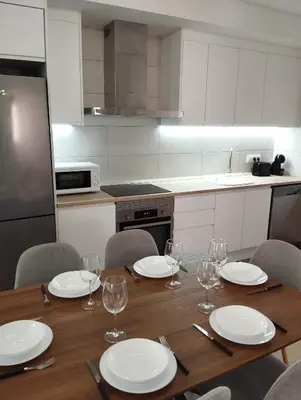 a kitchen with a wooden table with plates and wine glasses at CAN’SELMA 2 in Chella