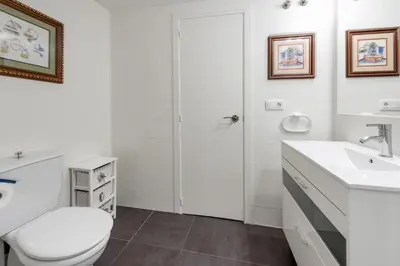 a white bathroom with a toilet and a sink at Latido Del Puerto in Puerto de Sagunto
