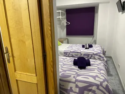 a bedroom with two beds and a door to a room at Albahicín in Puerto de Sagunto