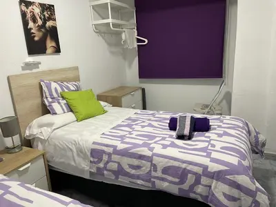 a bedroom with a bed with purple and green at Albahicín in Puerto de Sagunto