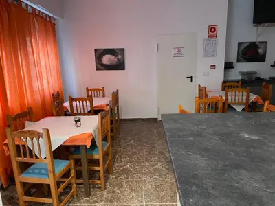 a dining room with tables and chairs and a door at Albahicín in Puerto de Sagunto