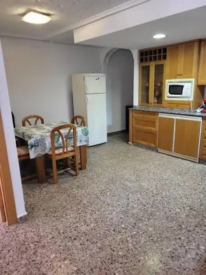 a kitchen with a table and a white refrigerator at carrer de la pau port de sagunto in Valencia