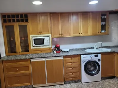 a kitchen with a washing machine and a microwave at carrer de la pau port de sagunto in Valencia