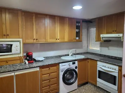 a kitchen with a washing machine and a microwave at carrer de la pau port de sagunto in Valencia