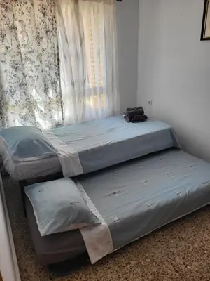 two twin beds in a room with a window at carrer de la pau port de sagunto in Valencia