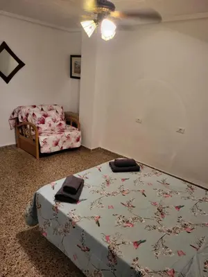 a bedroom with a bed and a chair at carrer de la pau port de sagunto in Valencia