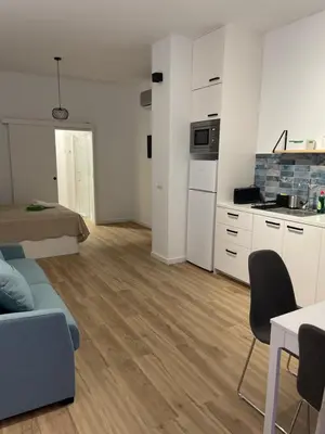 a living room with a couch and a kitchen at Carbonell by VivoGCFlats in Valencia