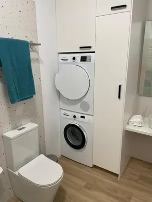 a bathroom with a toilet and a washing machine at Carbonell by VivoGCFlats in Valencia