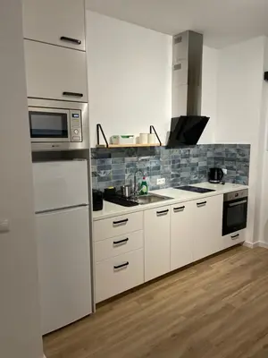 a kitchen with white cabinets and a microwave at Carbonell by VivoGCFlats in Valencia