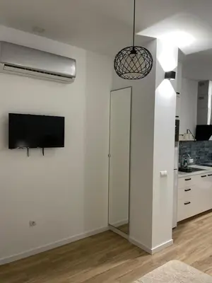 a living room with a tv and a white wall at Carbonell by VivoGCFlats in Valencia