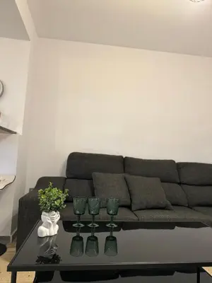 a living room with a couch and a table with wine glasses at comfortable apartment in an elite area with a beautiful veranda in Port Saplaya