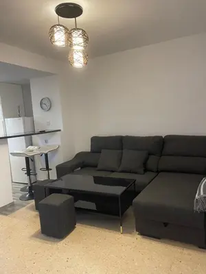 a living room with a couch and a table at comfortable apartment in an elite area with a beautiful veranda in Port Saplaya