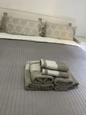a bed with three towels sitting on top of it at comfortable apartment in an elite area with a beautiful veranda in Port Saplaya