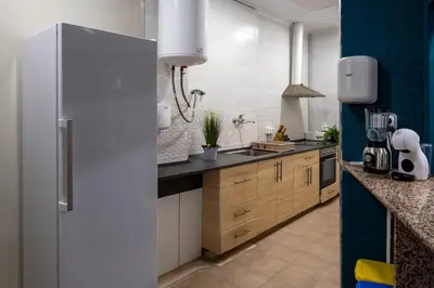 a kitchen with a refrigerator and a sink at SOM Hostel Valencia in Valencia