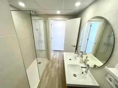 a bathroom with a sink and a shower and a mirror at NUEVO, a 80 metros del mar y la playa in Cullera