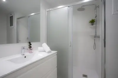a white bathroom with a shower and a sink at SingularStays Cullera V in Cullera