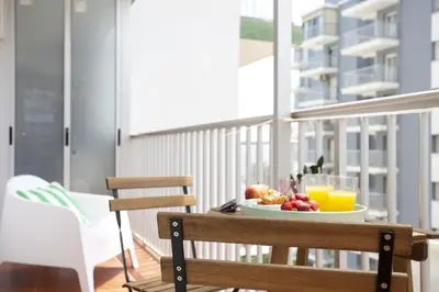 a plate of fruit and orange juice on a table on a balcony at SingularStays Cullera V in Cullera