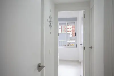 a hallway with a white door and a window at SingularStays Cullera V in Cullera